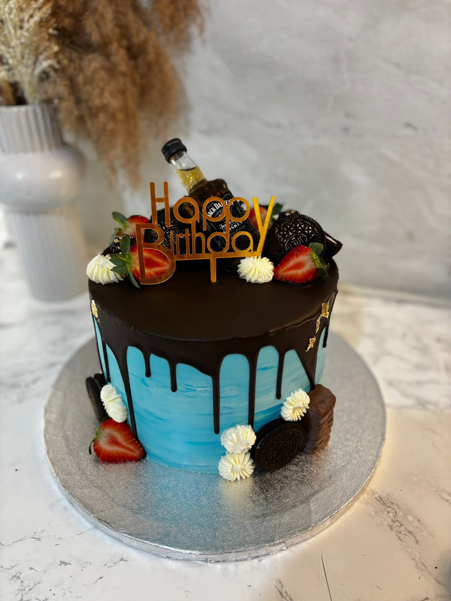 Blue cake with chocolate drip, Oreo biscuits and birthday topper