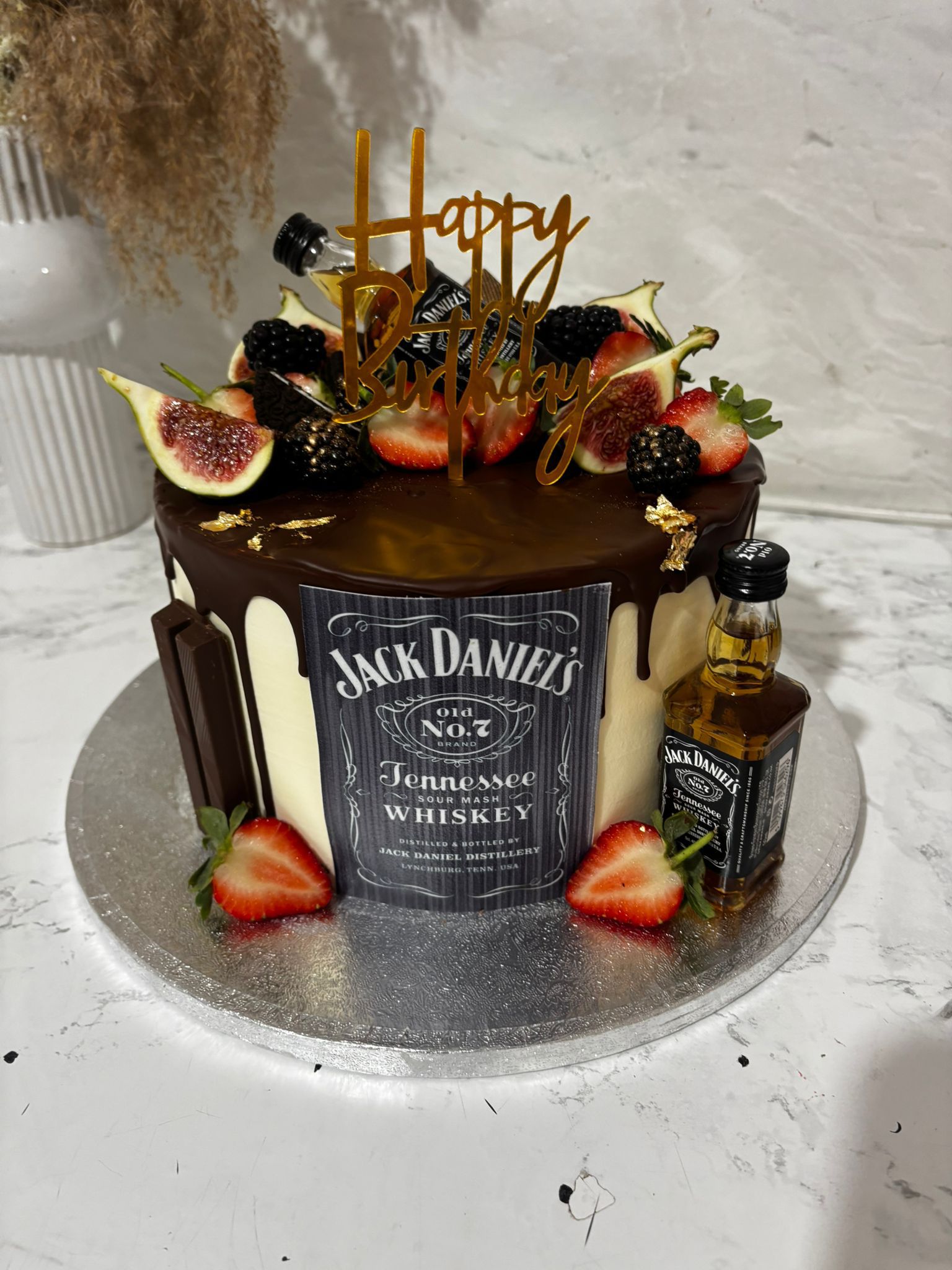 Chocolate drip cake with Jack Daniel’s theme and fresh fruit
