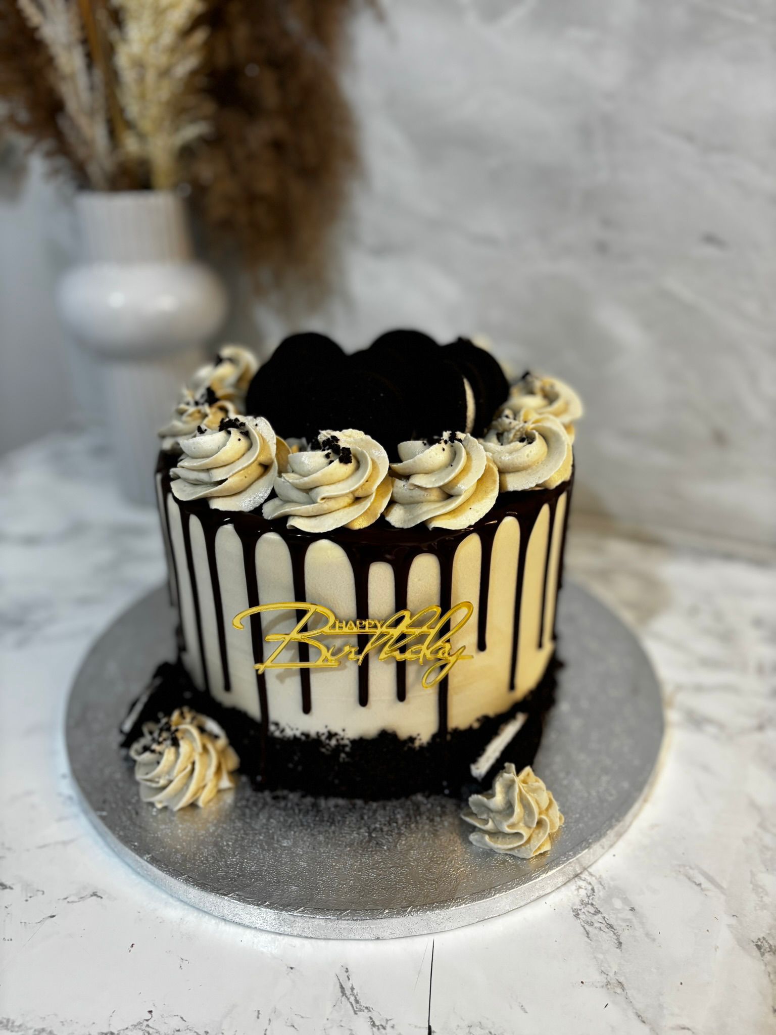 Drip cake with Oreo biscuits and piped cream swirls