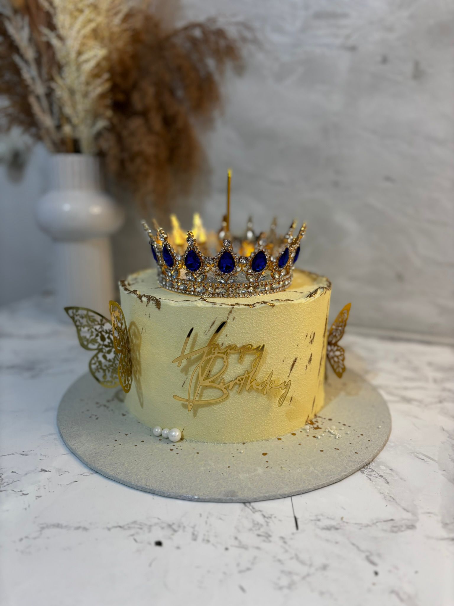 Cake with royal blue crown topper and gold accents